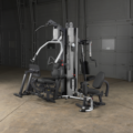 A gym machine is sitting on a wooden floor in a dark room - image