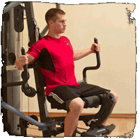 A man in a red shirt is sitting on a machine