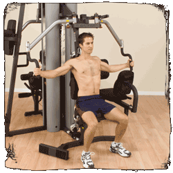 A shirtless man is using a machine in a gym