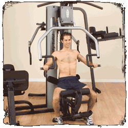 A shirtless man is sitting on a machine in a gym